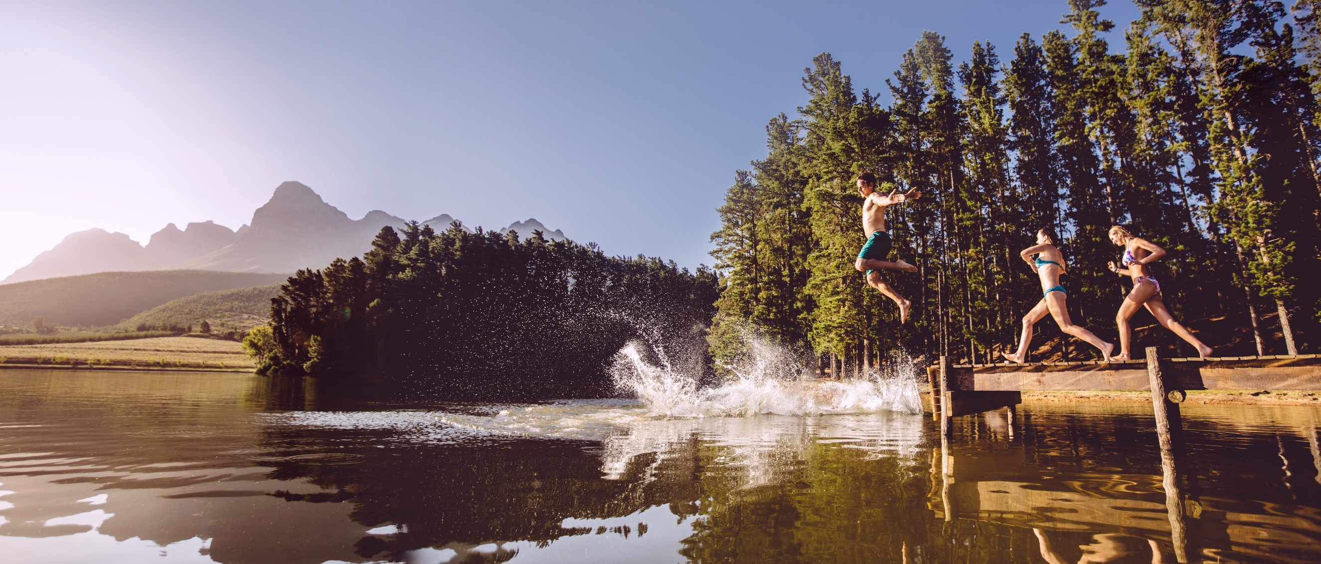 Swimmers Jumping Off Dock into Lake